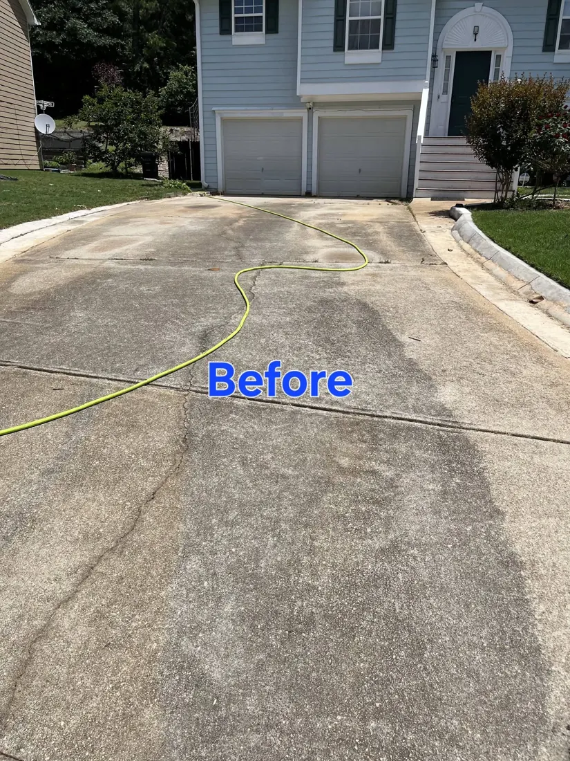 Same driveway before pressure washing, stained and dark